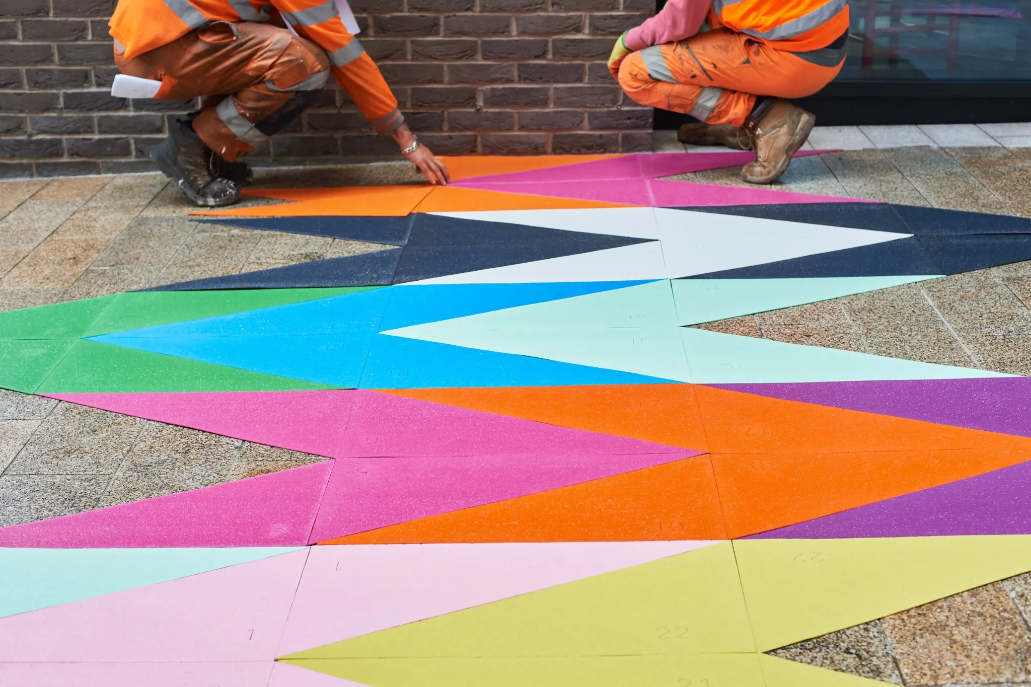 Installation team positioning the coloured geometric artwork pieces